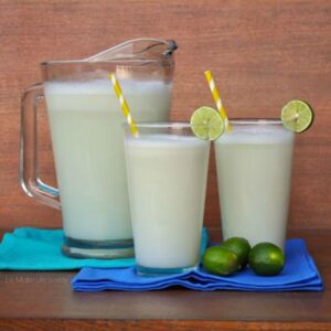 brazilian limeade in two clear glasses and a clear pitcher