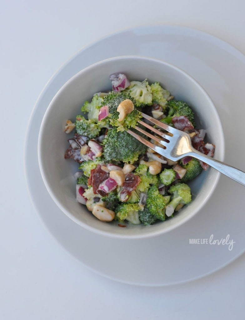 healthy broccoli salad with bacon in white bowl with fork