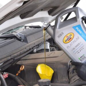 motor oil pouring into a yellow funnel