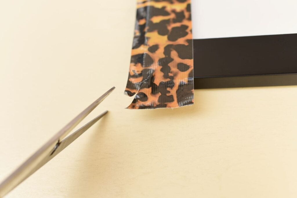 scissors cutting duck tape on frame