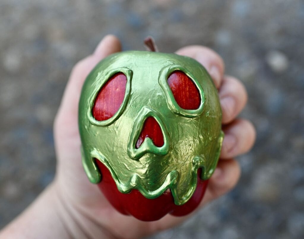 hand holding green poison apple