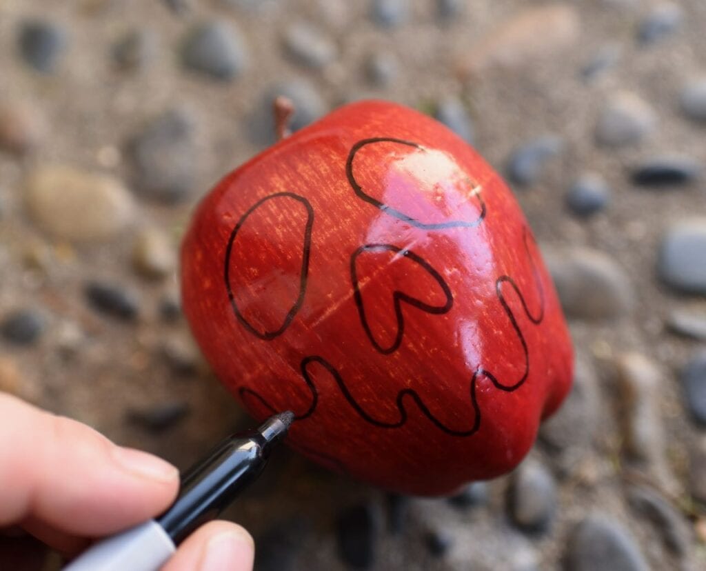 red apple with face draw on