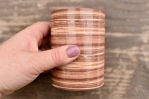 hand holding wood grain round container
