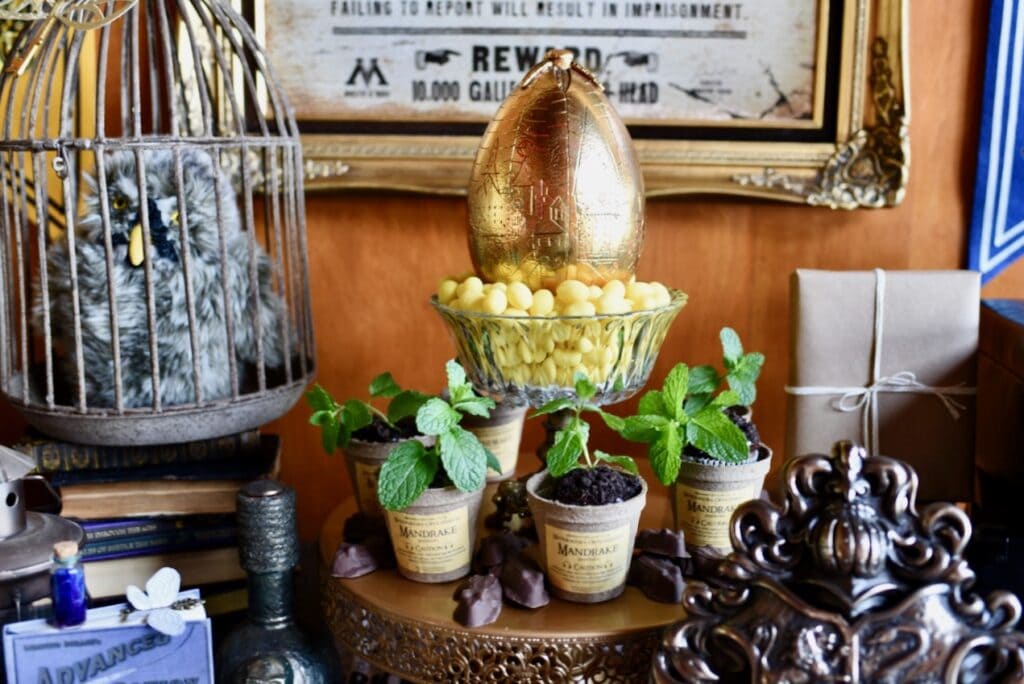 large gold egg sitting in lemon drops by bird cage with owl