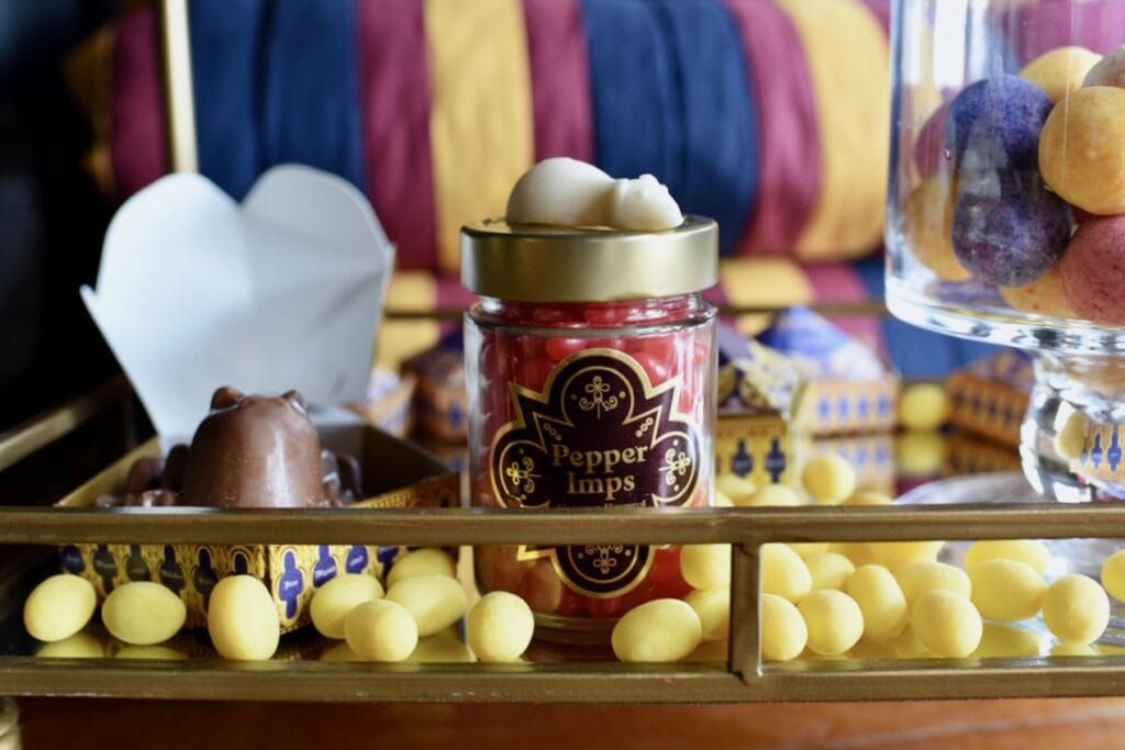 red candies in glass jar next to lemon drops