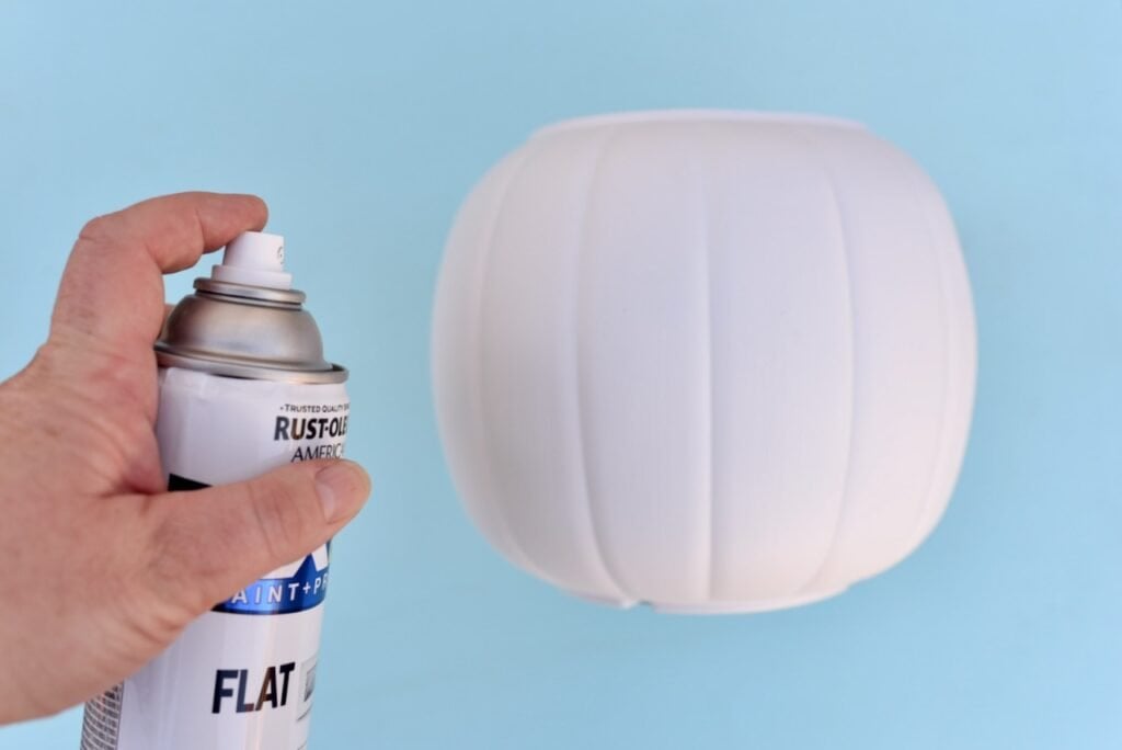 hand spray painting plastic pumpkin pail