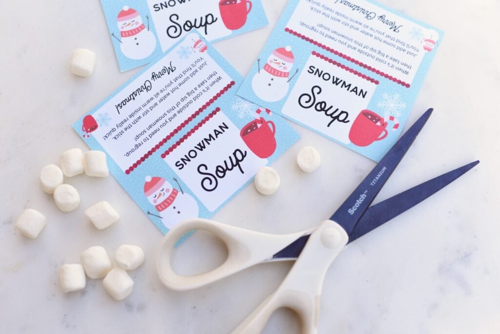 marshmallows and scissors next to printed labels on marble background