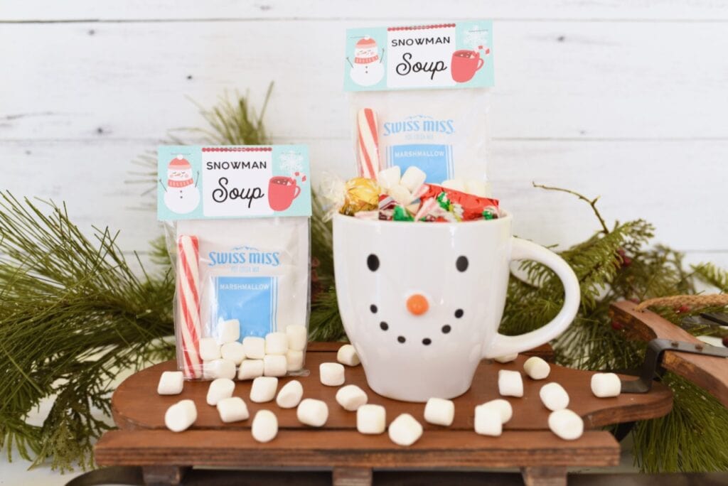white snowman mug with candy inside next to marshmallows