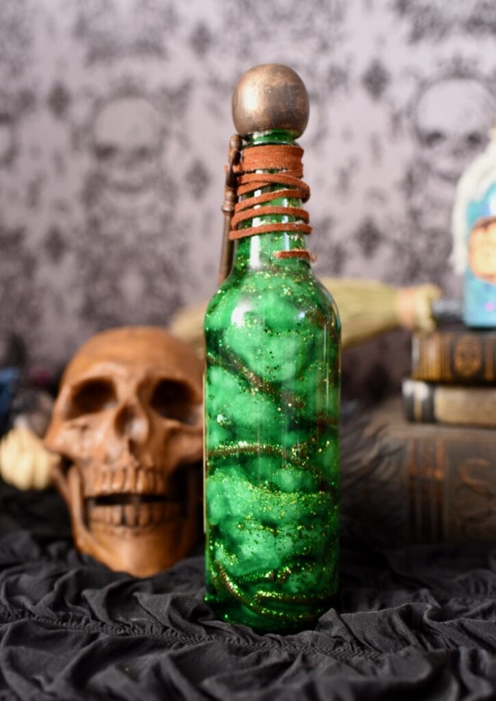 green swirly liquid in tall glass bottle