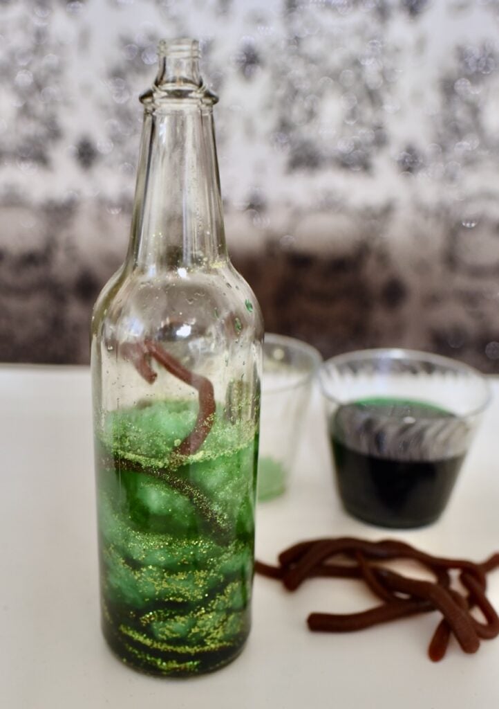 worms in glass with green liquid inside