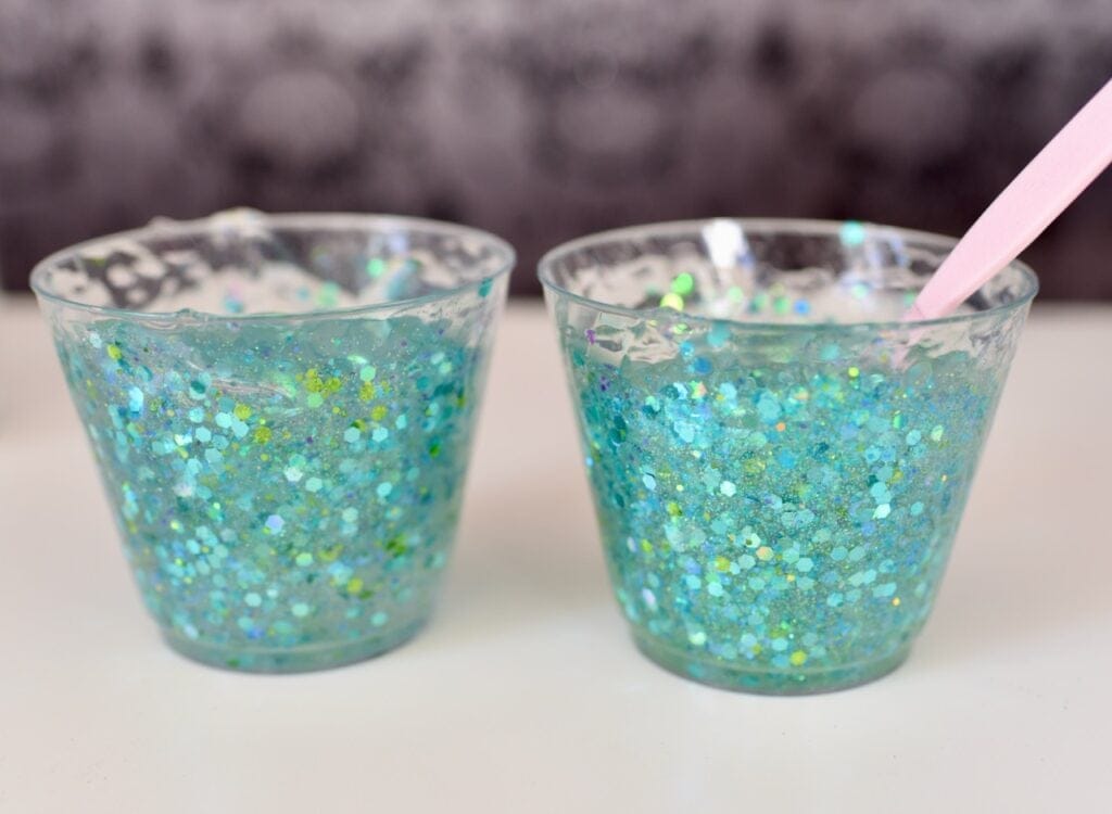 Two clear plastic cups filled with shimmery blue gel