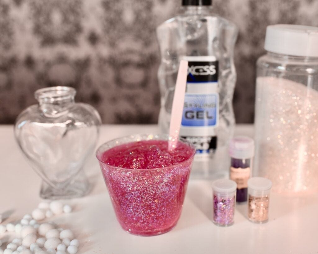 cup filled with pink glitter gel with spoon inside