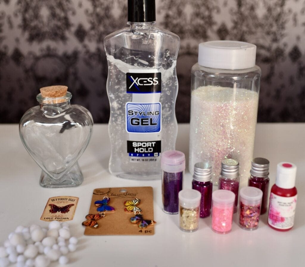 clear hair gel next to pink and whit glitter and butterfly charms