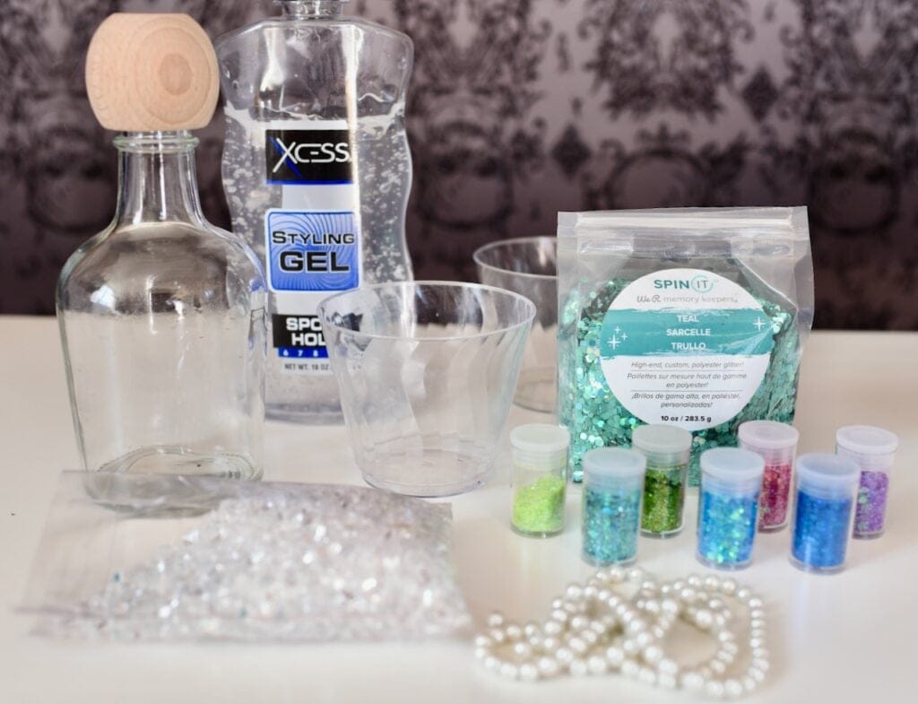 clear cups next to jars of blue and green glitter