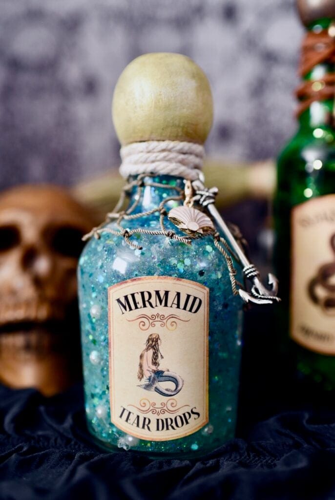 Blue glitter potion in glass bottle with anchor and shell charm