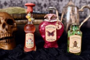 glass potion bottles with labels next to Halloween skull