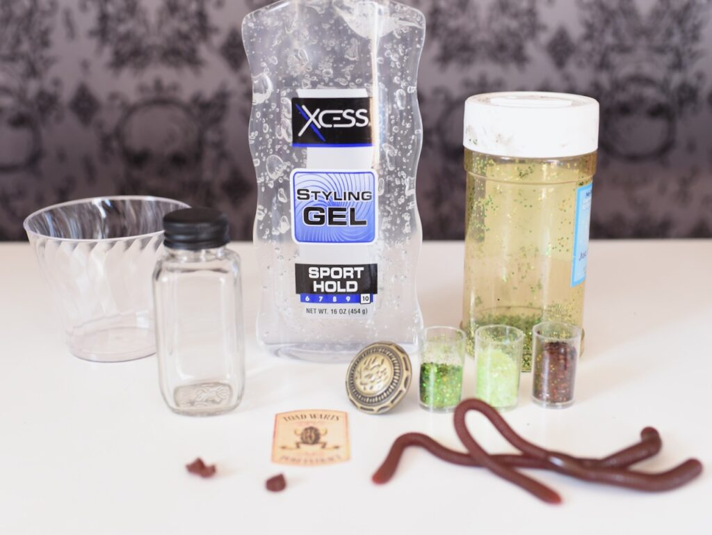 clear hair gel, clear cup, green glitter, and fake worms