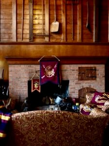 big brick fireplace with wood paneling and red couch