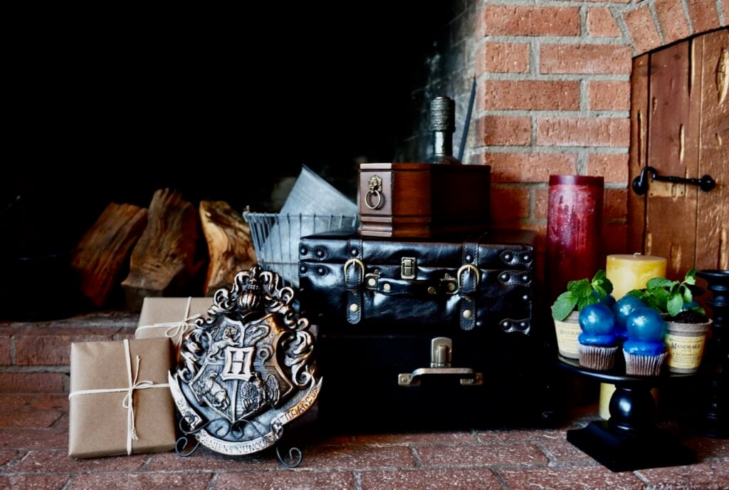 Harry Potter objects next to large brick fireplace