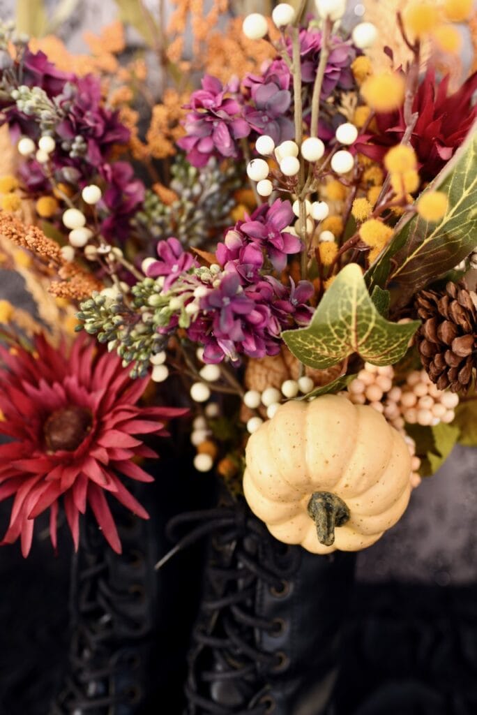 fall colored flowers and small white pumpkin