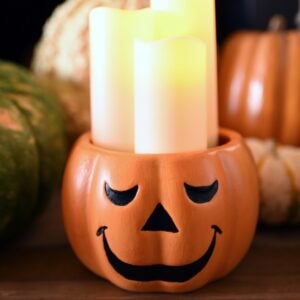 orange jack o' lantern with smiling face with candles inside