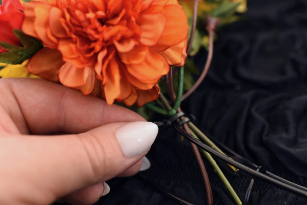 hand adding zip tie to fake flowers
