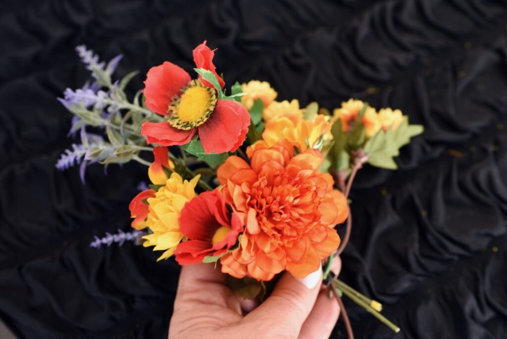 hand holding small fake flowers bouquet