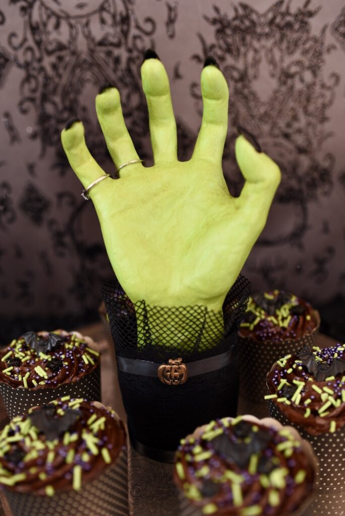 green hand with black nails on silver Halloween tray