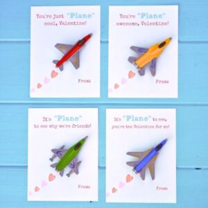 four paper airplane valentines with toy planes on them